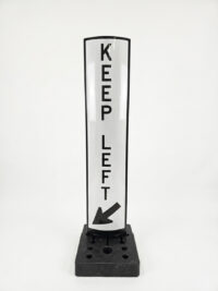 Black and white reflective Keep Left delineator blade with a diagonal arrow, mounted on a heavy black base